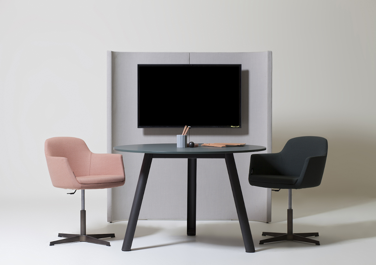 Composizione di un tavolo Apollo tra due sedute Vogue e il portamonitor della collezione Undecided