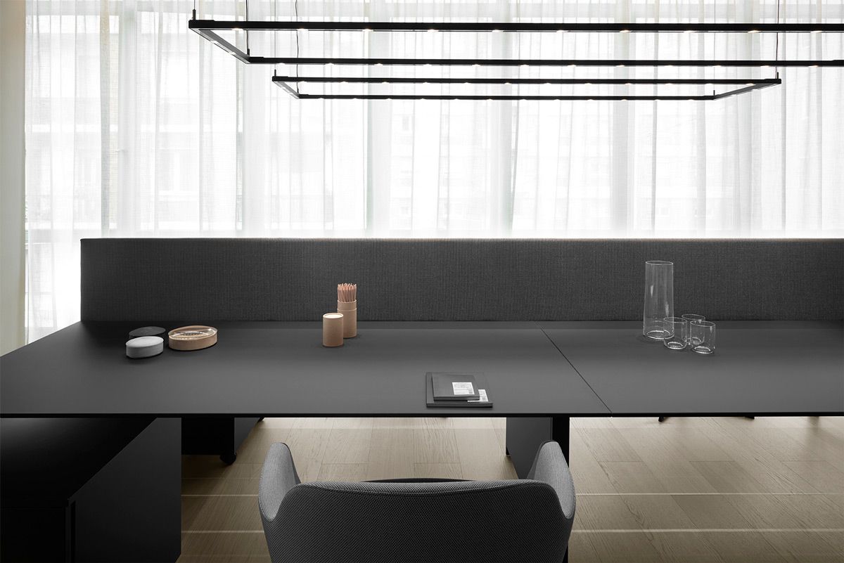 Foto di una scrivania manageriale di design con oggetti ordinati e schermo separatore in tessuto