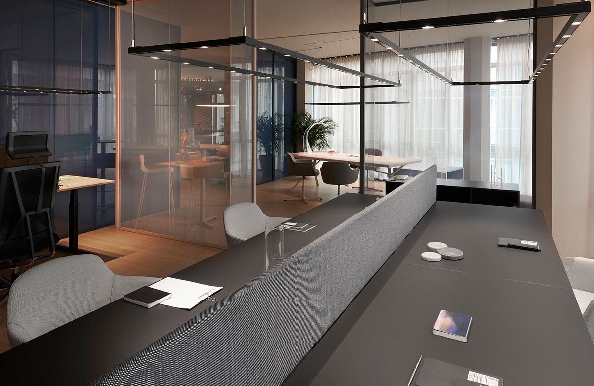 Vista interna di stanze manageriale divise da vetrate con tavolo con separatore K-Word