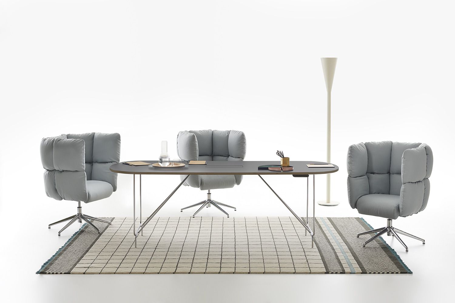 Foto still life di un tavolo collezione Litta con tre poltrone di design